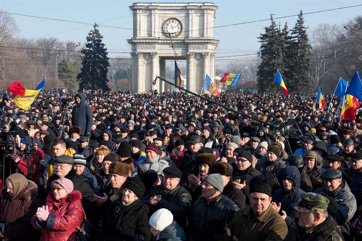 People attend the rally in front of the Parliament building in Chisinau on January 21, 2016. Moldova braced for fresh protests on January 21 after the opposition called for more demonstrations against a new government that was secretly sworn in overnight. / AFP / DORIN GOIAN (Photo credit should read DORIN GOIAN/AFP/Getty Images)